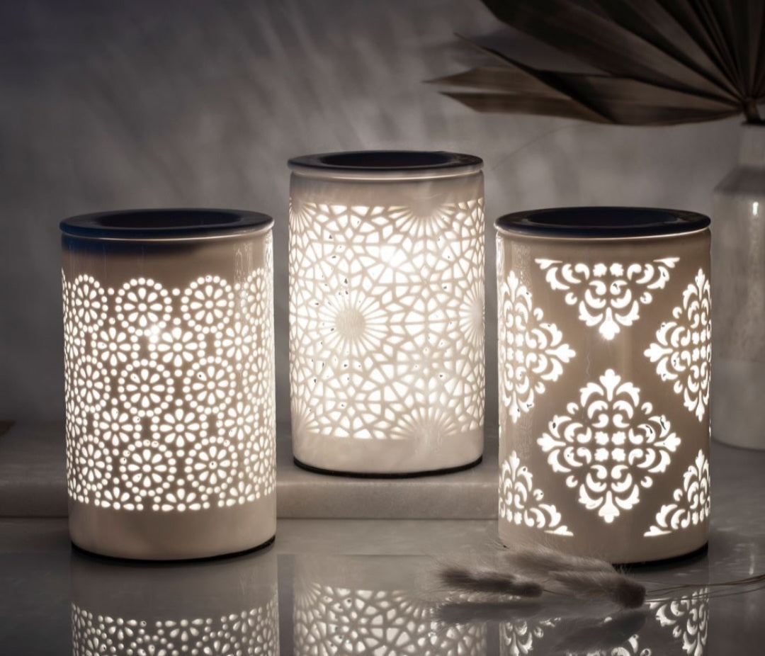 Three electric burners with intricate geometric patterns, illuminated from the inside, displaying a warm glow.